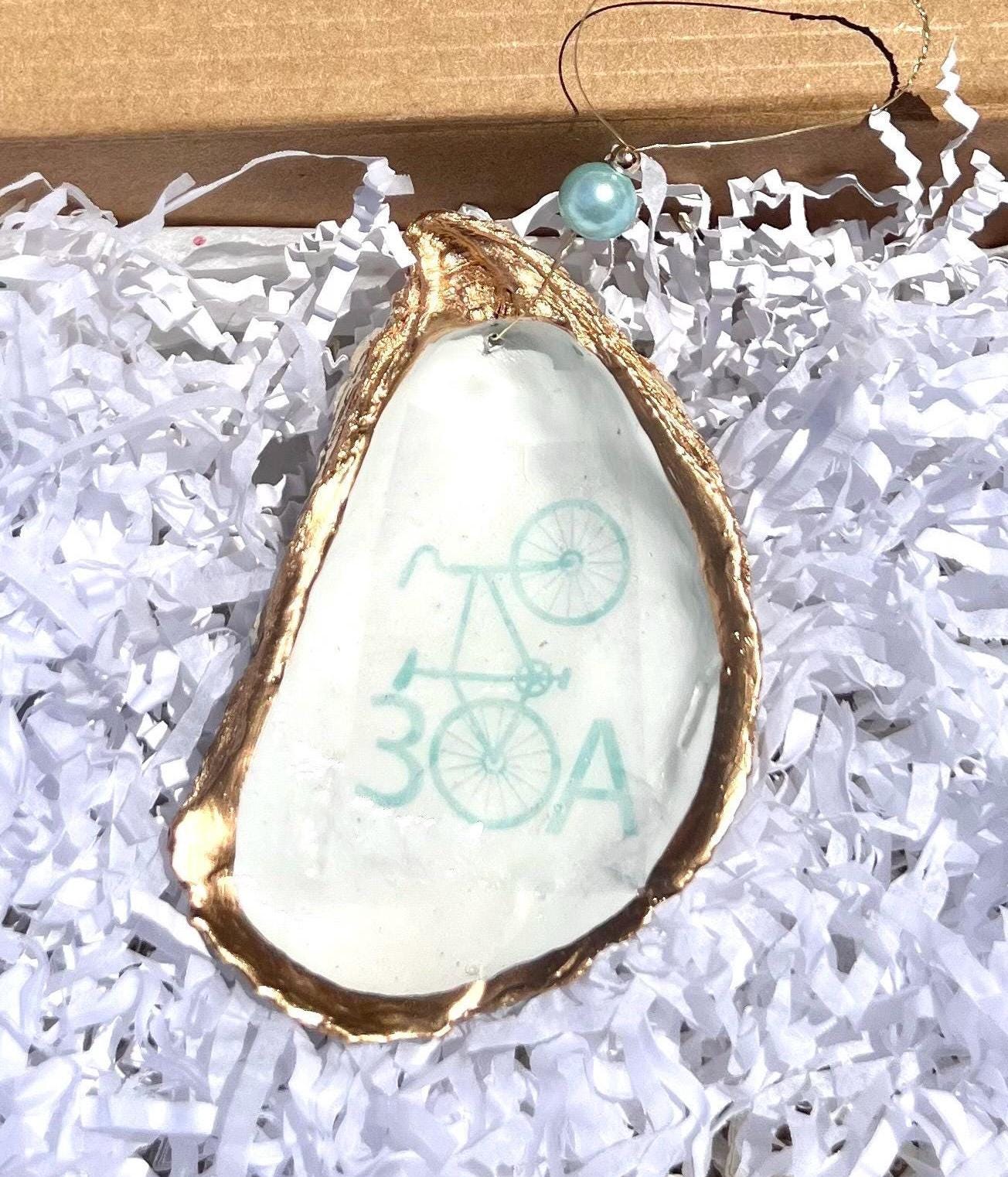 oyster shell with an Aqua 30a sign and a bicycle