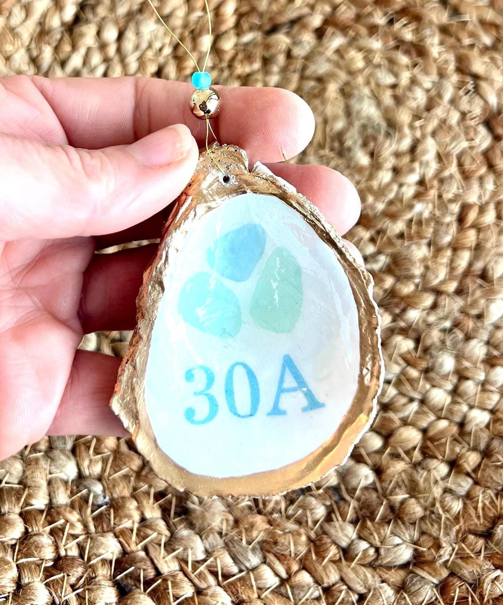 oyster shell ornament with pictures of small pastel and aqua sea glass and the words 30a