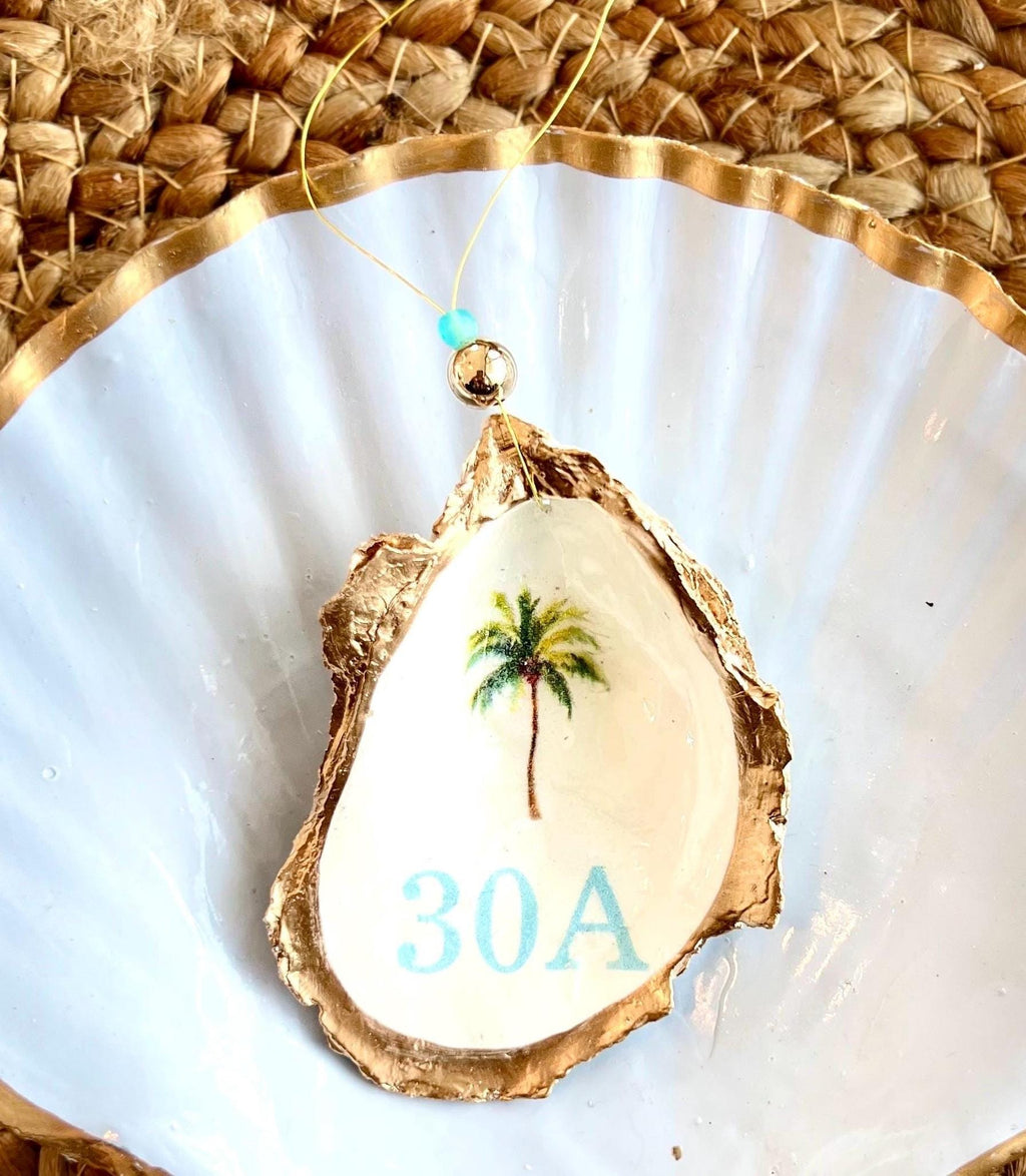 Oyster shell ornament with a picture of a palm tree and the words 30 a